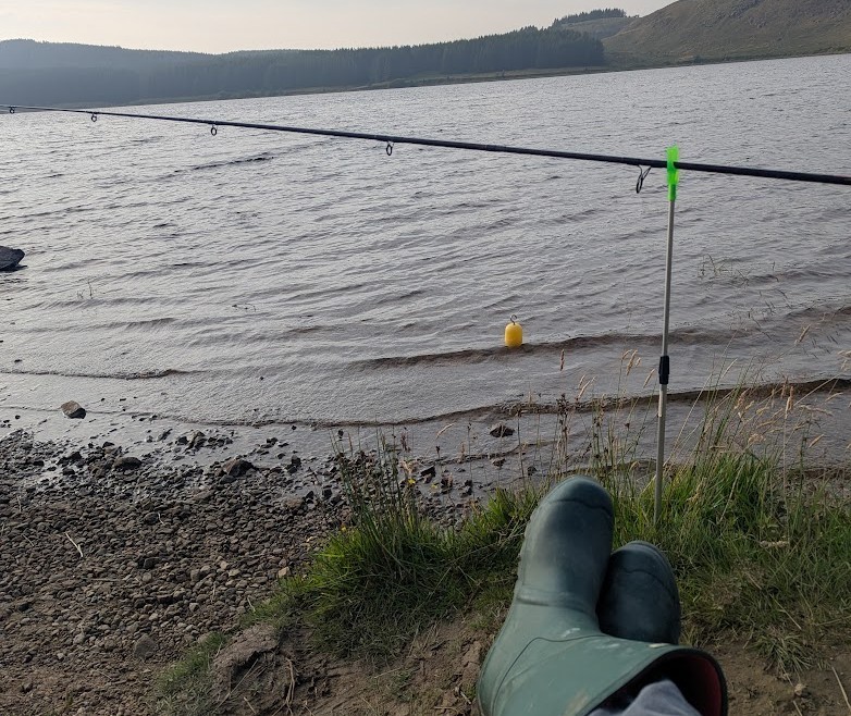 A mans wellys next to a body of water