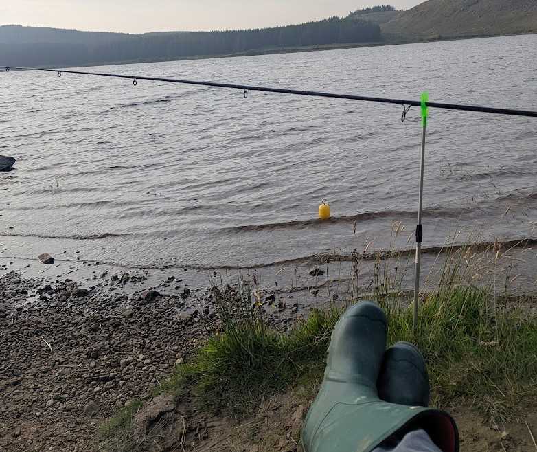 A mans wellys next to a body of water